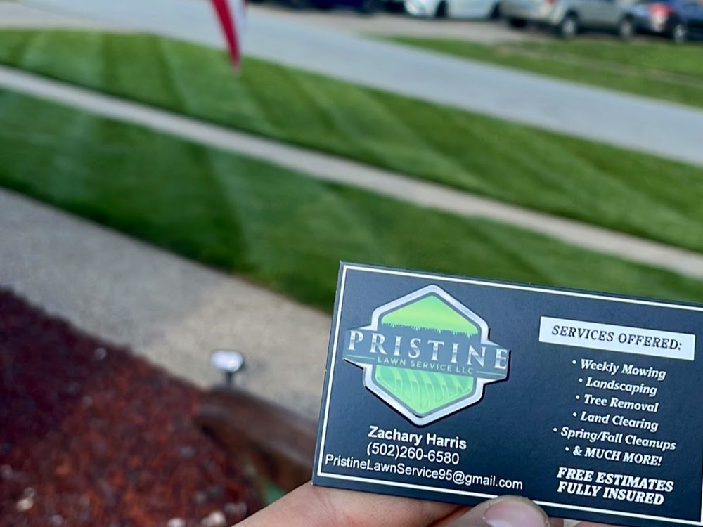 The company’s printed estimate card held over a freshly striped lawn, showing the shield logo, the service list, and the words Free Estimates and Fully Insured.